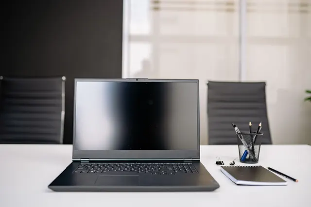 Ordinateur portable posé sur la table blanche d'une salle de réunion